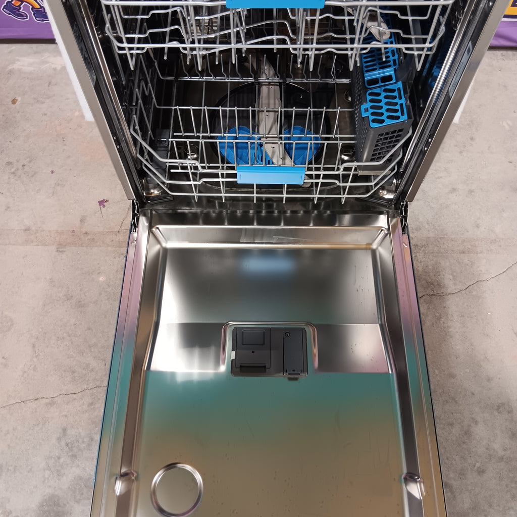 GE PDT715SYVFS Open dishwasher with racks on a tiled floor.