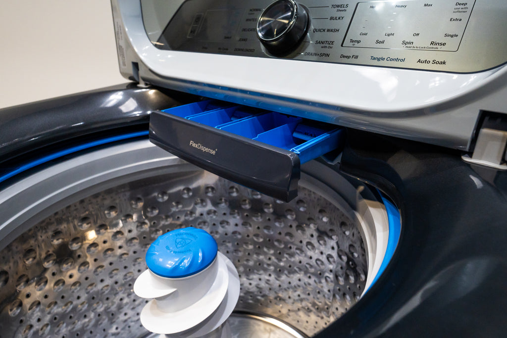 GE PTW605BPRDG washer with a blue and white cylindrical object inside, likely a dryer sheet or fabric softener.