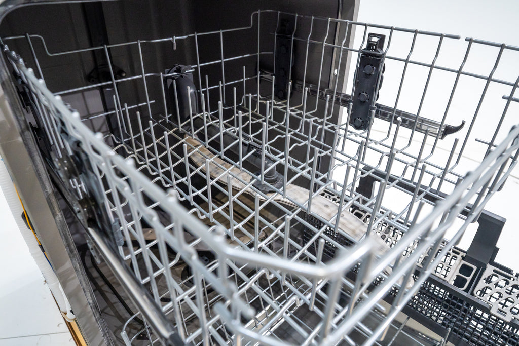 GE GDT565HSYSS Open dishwasher with silverware and dishes inside on a white background