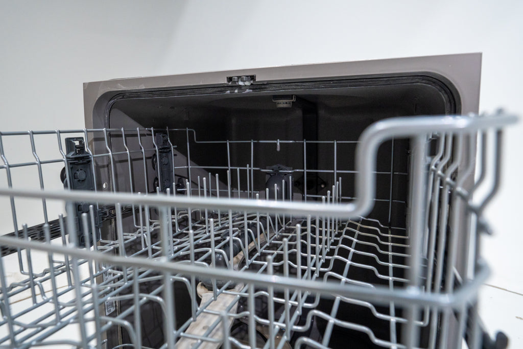 GE GDT565HSYSS Open dishwasher with empty racks on a white background