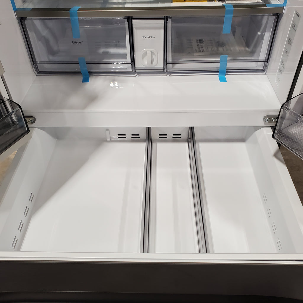 Empty Samsung Bespoke 4-Door French Door RF29BB8600QL Refrigerator with glass door panels and blue tape on a white background