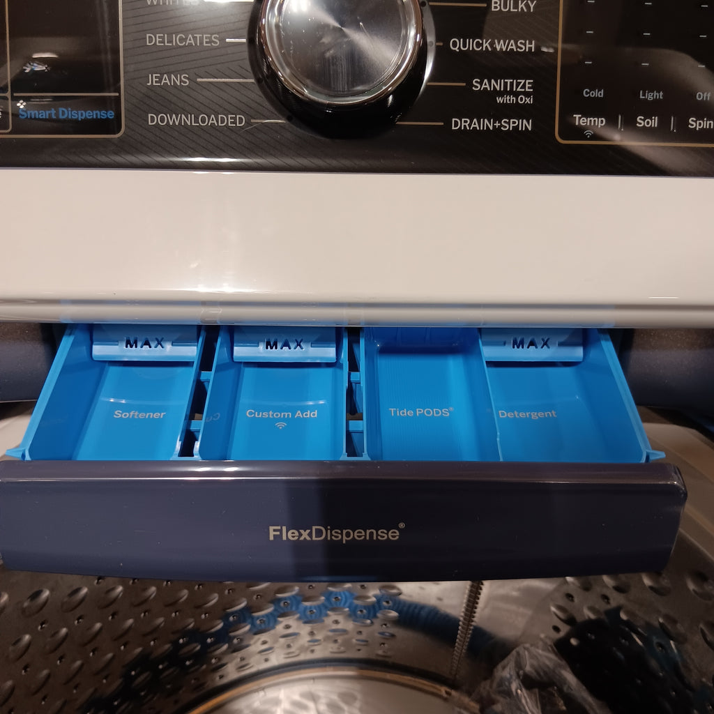 GE PTW805BPWRS FlexDispense laundry detergent dispenser with blue pods inside a washing machine.