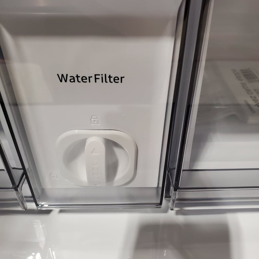 Close-up of a water filter compartment on a Samsung Bespoke 4-Door French Door RF29BB8600QL Refrigerator with 'Water Filter' label.