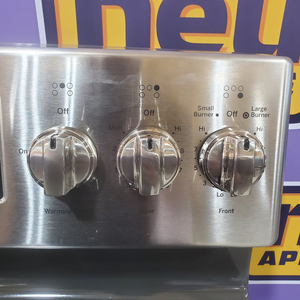 Stainless steel GE Free-Standing 30" Electric Double Oven Convection Range JBS86SPSS control panel with three knobs on a colorful background