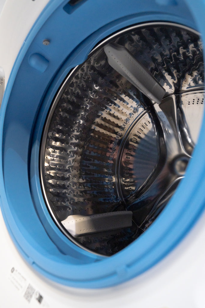 GE GFW550SSNWW Close-up of a washing machine drum with blue exterior