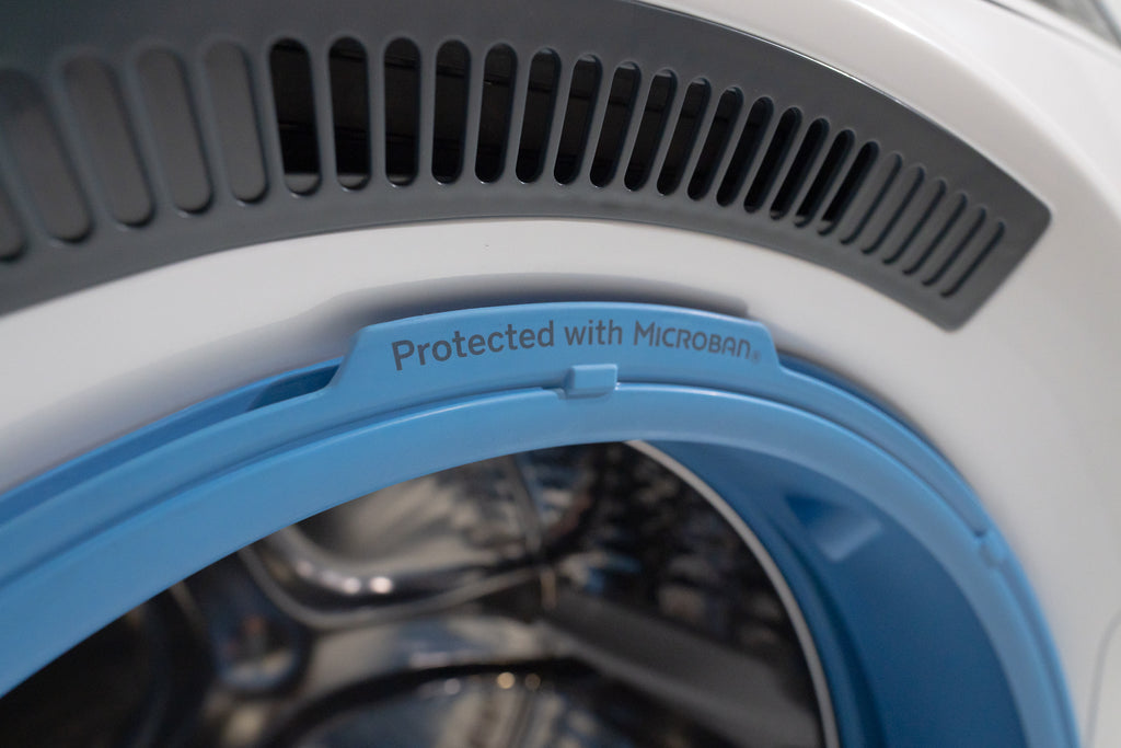 GE GFW550SSNWW Close-up of a washing machine with 'Protected with Microban' label