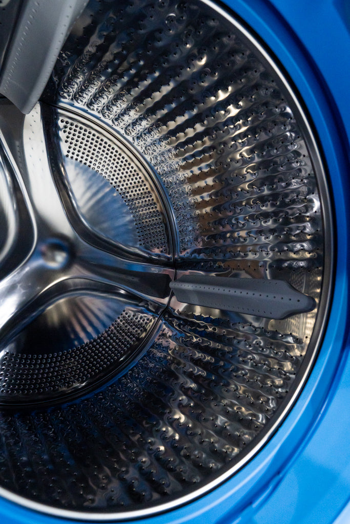 GE Profile PFQ97HSPVDS Close-up of a blue washing machine drum with a black agitator.