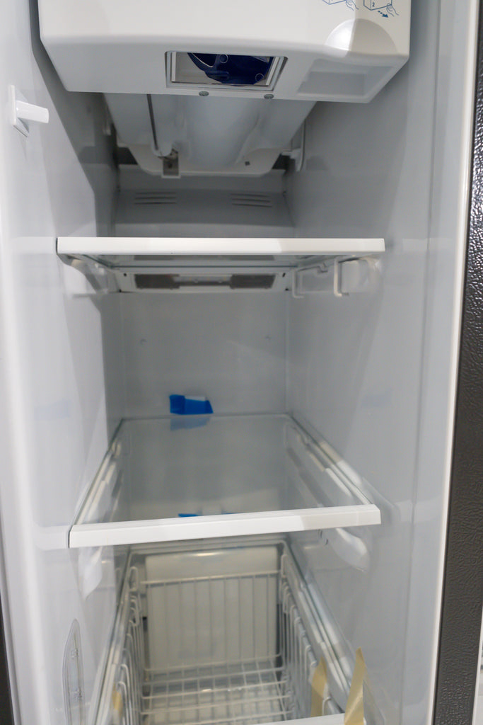 GE GSS25IYN Empty refrigerator interior with shelves and ice maker visible.