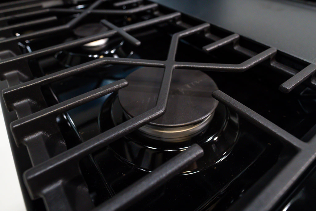 GE GGF600AVSS Close-up of a gas stove burner with black grates